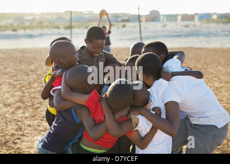 Jungen zusammengekauert auf Schmutz-Gebiet Stockfoto