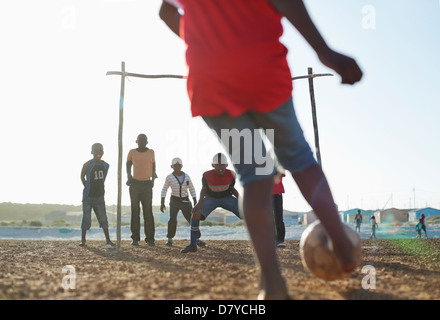 Jungs spielen Fußball zusammen in Schmutz Feld Stockfoto