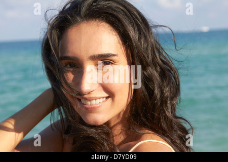 Hispanic Frau lächelnd am Strand Stockfoto