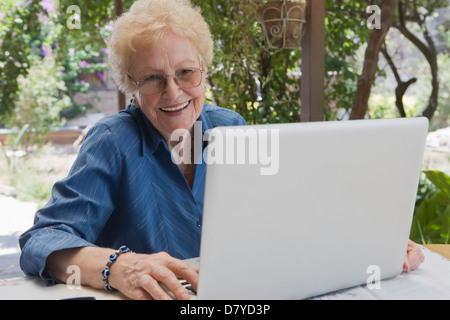 Ältere Hispanic Frau mit Laptop im freien Stockfoto