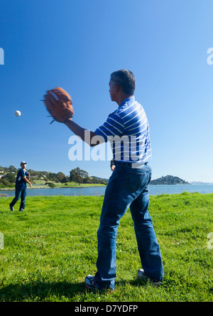 Hispanische Vater und Sohn spielen fangen im park Stockfoto