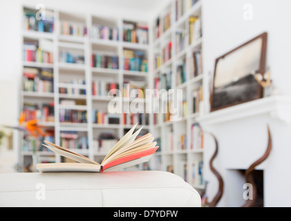 Offenes Buch am Arm des Sofas im Wohnzimmer Stockfoto