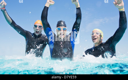 Triathleten in Neoprenanzüge in Wellen plätschern Stockfoto