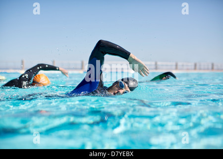 Triathleten in Neoprenanzüge racing im pool Stockfoto