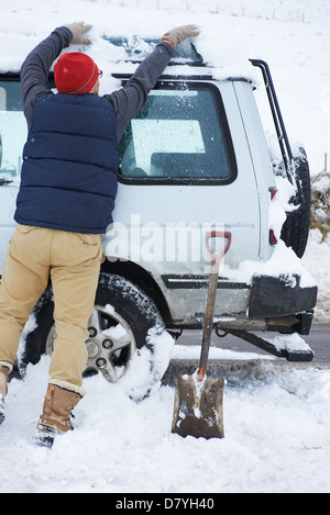 Mann Graben Auto aus Schnee Stockfoto