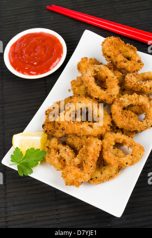 IKA Furai - tief gebratene panierte Tintenfischringe mit Chili-Sauce. Stockfoto