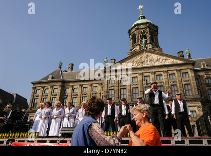 Niederländische Menschen tanzen und singen vor dem königlichen Palast, Dam Square, Amsterdam, Niederlande Stockfoto