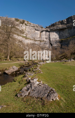 Sonnige Aussicht auf Wasser im Kessel von Malham Cove unter blauem Himmel - mit einem riesigen, steilen, gewundenen Kalksteinfelsen in wunderschönen Yorkshire Dales, England, GB, UK. Stockfoto