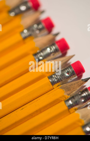 Close-up Detail von scharfen gelben Bleistifte mit roten Beläge am Ende, aufgereiht, abwechselnd von oben nach unten auf weißem Hintergrund - Yorkshire, England, UK. Stockfoto