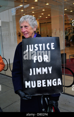 Eine Frau hält einen schwarzen Plakat "Gerechtigkeit für Jimmy Mubenga" vor dem Sitz der G4S. Stockfoto