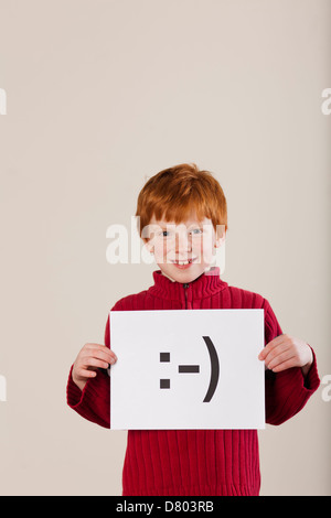 Kaukasische junge hielt Karte mit Smiley-Gesicht Stockfoto