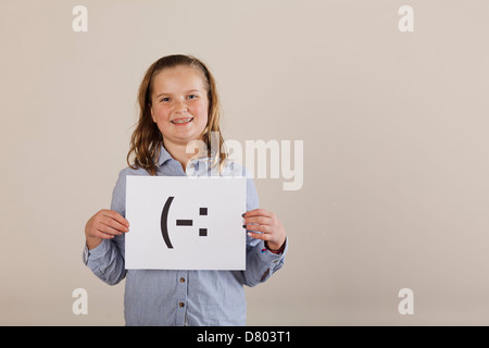 Kaukasische Mädchen hielt Karte mit Smiley-Gesicht Stockfoto