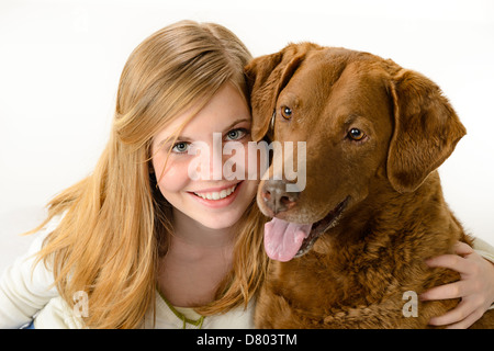 Niedliche Mädchen hält einen Hund über weißem Hintergrund Stockfoto