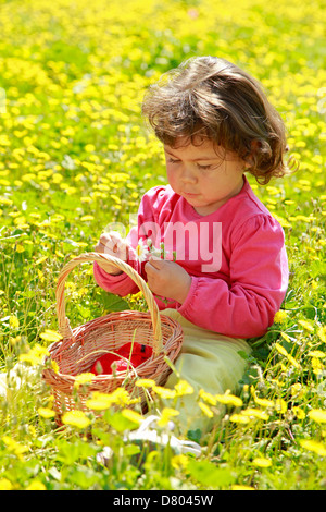 Kleines Mädchen mit Mohn und anderen Blumen. Stockfoto