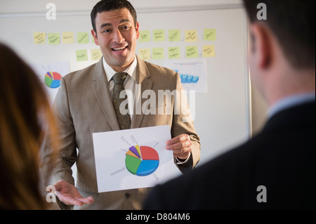 Geschäftsmann mit Graphen in treffen Stockfoto