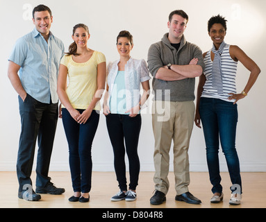 Freunde lächelnd zusammen drinnen Stockfoto