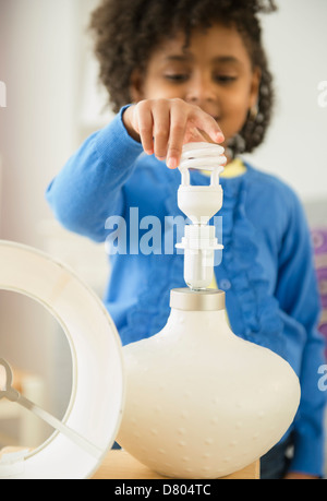 Afroamerikanische Mädchen Auswechseln der Glühbirne Stockfoto