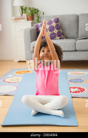 Afroamerikanische Mädchen praktizieren Yoga im Wohnzimmer Stockfoto