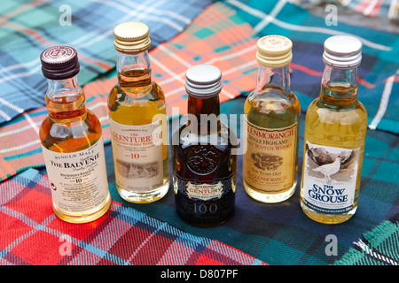 Auswahl an Miniatur Scotch Whiskys und traditionellen schottischen Clan tartans Stockfoto