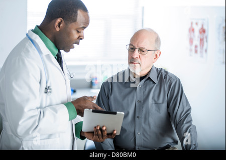 Afrikanische amerikanische Arzt im Gespräch mit Patienten im Büro Stockfoto