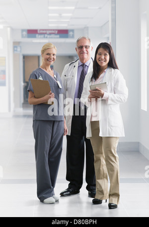 Ärzte und Krankenschwester im Krankenhaus lächelnd Stockfoto