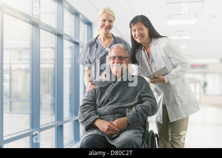 Arzt und Krankenschwester lächelnd mit Patienten im Krankenhaus Stockfoto