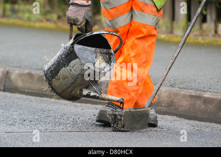 Teer wird auf einer Straße aus einer Gießkanne, Walsall, West Midlands gekippt Stockfoto
