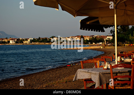 Freie Tische im Restaurant, Küste und sandigen Strand im Hintergrund. Stockfoto