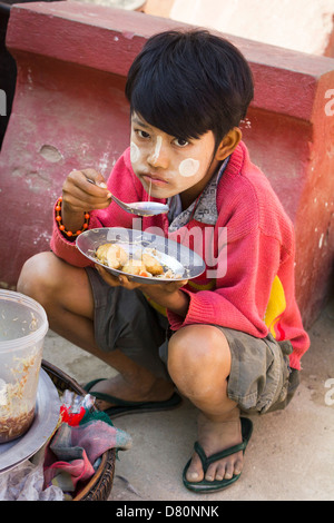 Ein kleiner Junge isst Mittagessen in Mingun, Myanmar Stockfoto