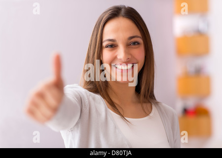helles Bild der jungen Frau mit Daumen nach oben Stockfoto