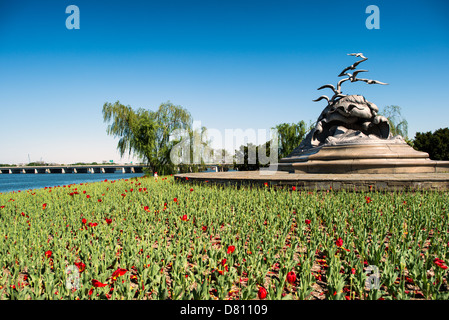 WASHINGTON DC, USA – die 14th Street Bridge (Hintergrund links) mit dem Navy-Merchant Marine Memorial in Arlington, Virginia, auf Columbia Island am Ufer des Potomac gegenüber Washington DC. das Denkmal ehrt diejenigen, die im Ersten Weltkrieg ihr Leben auf See verloren haben. es wurde 1934 eingeweiht. Die Hauptskulptur ist aus Aluminium gegossen. Im Hintergrund befindet sich ein Teil der 14th Street Bridge. Stockfoto