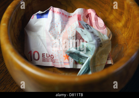 10 vermasselt ein 5 Euro-Banknoten in eine braune Schale Stockfoto