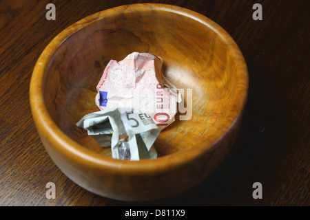 10 vermasselt ein 5 Euro-Banknoten in eine braune Schale Stockfoto