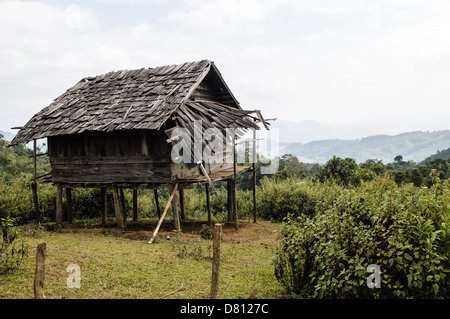 PROVINZ XIENG KHOUANG, Laos — Eine beschädigte hölzerne Reishütte befindet sich auf Stelzen in Nordlaos. Stockfoto