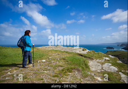 Eine weibliche Wanderer den Ausblick von der Küste in Tintagel in Nord Cornwall, England, UK Stockfoto