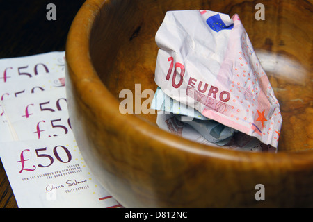 10 und 5 Euro-Banknoten in einer braunen Schale auf Sterling £50 Notizen vermasselt Stockfoto