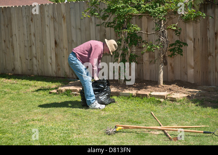 Eine 75 Jahre alte Senior kaukasischen Mann macht die Gartenarbeit an seinem Haus. Oklahoma, USA. Stockfoto