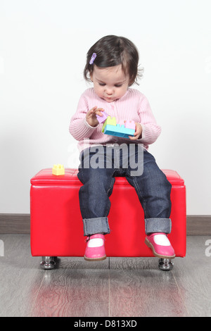 Baby spielt mit Konstruktionsspielzeug, die zu Hause sitzen Stockfoto