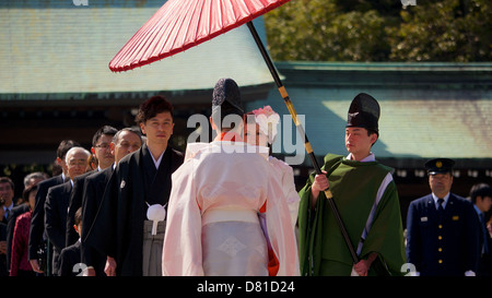 Japanische traditionelle Shinto Hochzeit im Meiji-Schrein mit Bright Red Gifu Regenschirm und Gefolge von Familie und Freunden Stockfoto