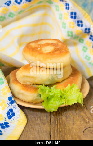 Gebratene frische leckere Fleisch oder Gemüse-Pastetchen (Kuchen) auf Holztisch (Hintergrund). Traditionellen Fastfood. Stockfoto