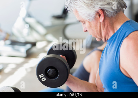 Älteren Hispanic Mann Heben von Gewichten im Fitnessstudio Stockfoto
