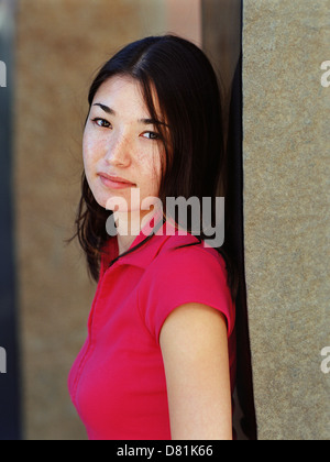 Gemischte Rassen Frau stützte sich auf Wand Stockfoto