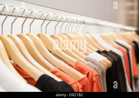 Kleidung zu hängen, auf einem Regal in einem Designer-Kleidung Geschäft in Melbourne, Australien Stockfoto