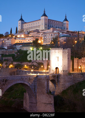 Toledo - Alcazar und Puente de Alcántara Brücke in Morgen-Dämmerung Stockfoto