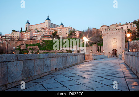 Toledo - Alcazar und Puente de Alcántara Brücke in Morgen-Dämmerung Stockfoto