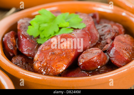 Chorizo al Vino (Chorizo in Rotwein gekocht). Traditionelle spanische Tapas Teller. Stockfoto