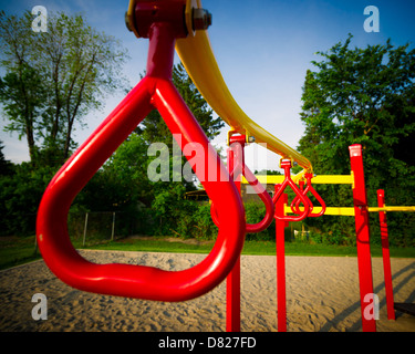 Zusammensetzung des hellen, roten schwingen und Klettern Bars Kinder spielen Struktur in einem öffentlichen Park. Stockfoto