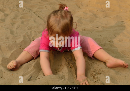 2 Jahre altes Mädchen spielen im Sand am Spielplatz Stockfoto