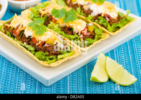 Rindfleisch Tacos - Hackfleisch-Taco-Schalen garniert mit Salsa, saure Sahne und geriebenem Käse. Stockfoto