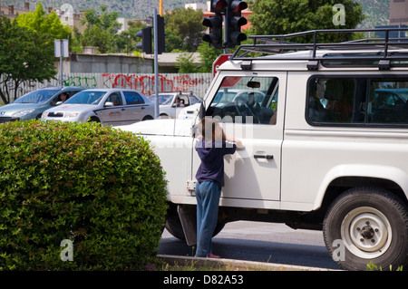 Kind wirft Geld aus Autofahrer an der Ampel in Mostar Bosnien-Herzegowina Stockfoto